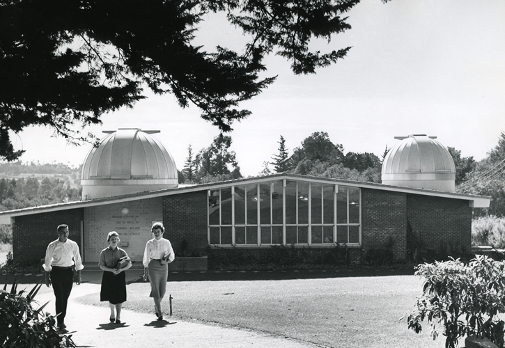 Three students walking in front of the Carroll Observatory.